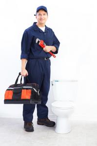 Plumber poses with equipment and toilet
